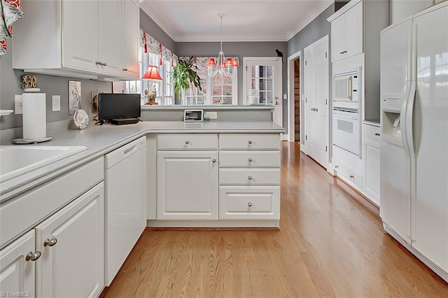 kitchen featuring light hardwood / wood-style flooring, crown molding, pendant lighting, white cabinets, and white appliances