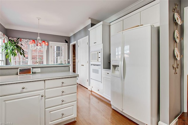 kitchen featuring hanging light fixtures, white cabinetry, a chandelier, light hardwood / wood-style floors, and white appliances