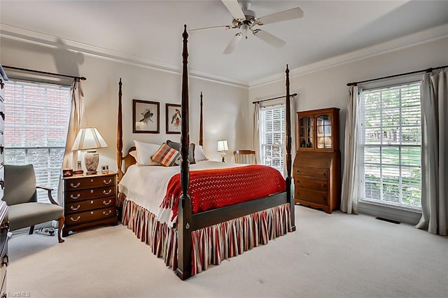 carpeted bedroom with ceiling fan, crown molding, and multiple windows