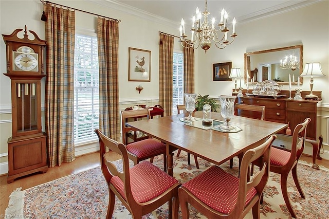 dining area featuring crown molding, a healthy amount of sunlight, a notable chandelier, and light wood-type flooring