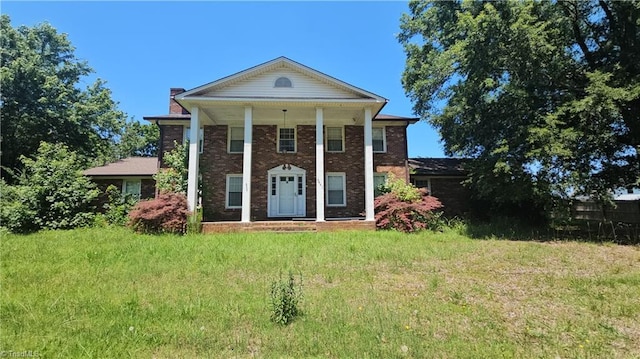 9441 County Line Rd, Kernersville, NC 27284 - neoclassical home featuring a chimney, a front lawn, a porch, and brick siding