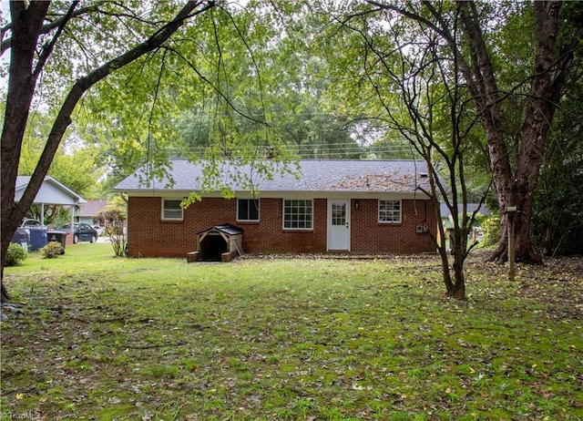 rear view of house featuring a lawn