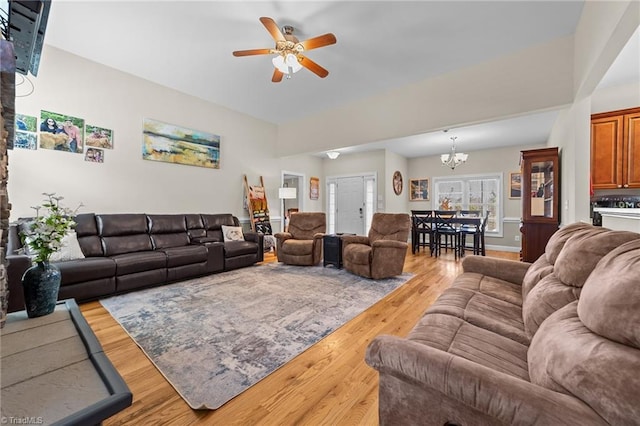 living room with ceiling fan with notable chandelier and wood-type flooring