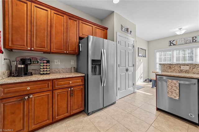 kitchen featuring stainless steel appliances, light tile patterned floors, and light stone counters