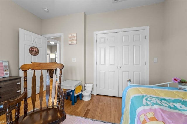 bedroom featuring wood-type flooring and a closet