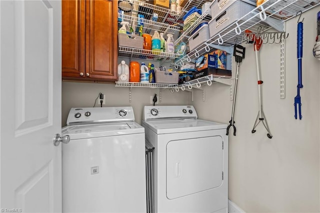 washroom featuring cabinets and washer and clothes dryer