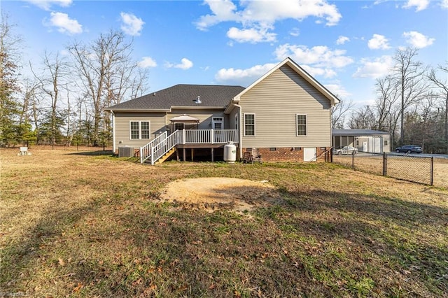 rear view of house featuring a lawn and a deck