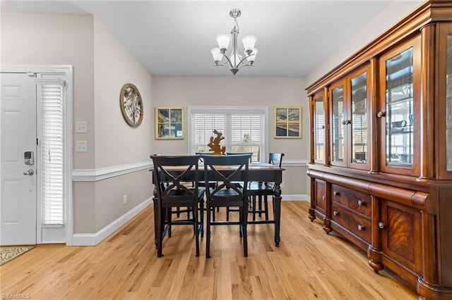 dining space with an inviting chandelier and light hardwood / wood-style flooring