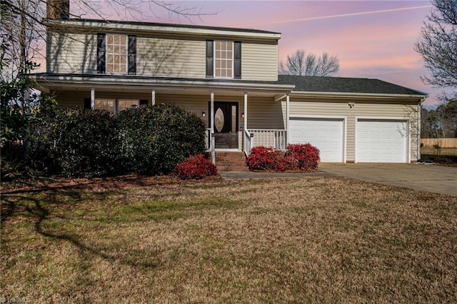 front of property with a garage, a yard, and covered porch