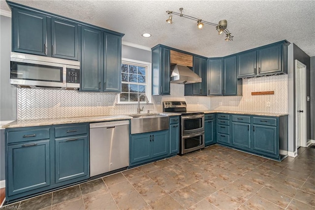 kitchen featuring sink, blue cabinetry, appliances with stainless steel finishes, tasteful backsplash, and extractor fan