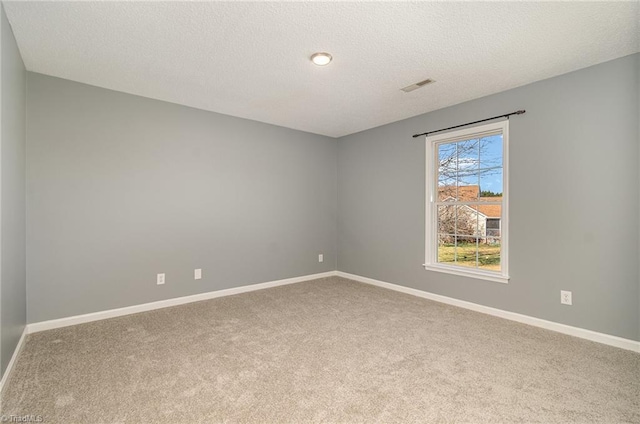 carpeted spare room with a textured ceiling