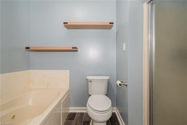 bathroom featuring hardwood / wood-style floors, a bath, and toilet