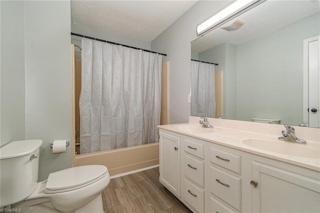 full bathroom featuring hardwood / wood-style flooring, vanity, toilet, a textured ceiling, and shower / bath combo with shower curtain