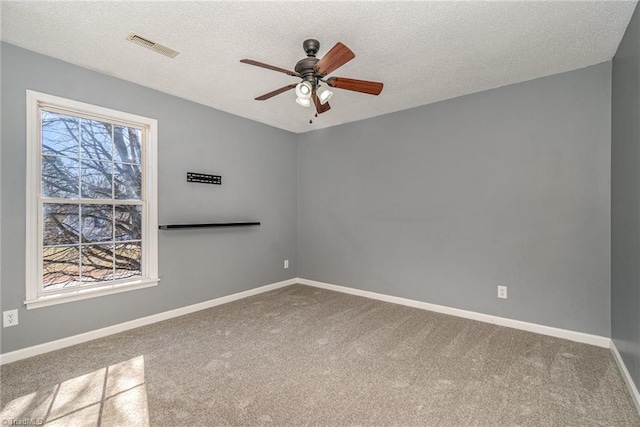 unfurnished room featuring ceiling fan, carpet, a wealth of natural light, and a textured ceiling