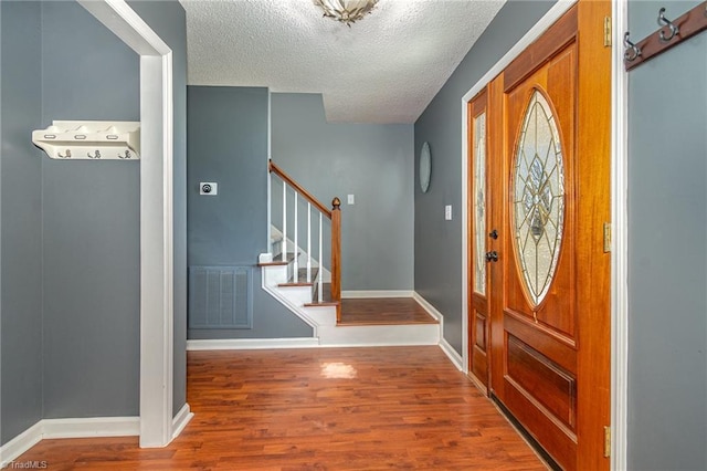 foyer featuring hardwood / wood-style flooring and a textured ceiling