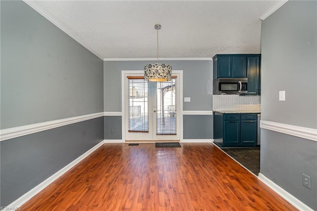 unfurnished dining area featuring dark hardwood / wood-style flooring and ornamental molding