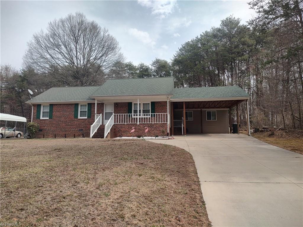 ranch-style home featuring covered porch, brick siding, a shingled roof, crawl space, and a front lawn