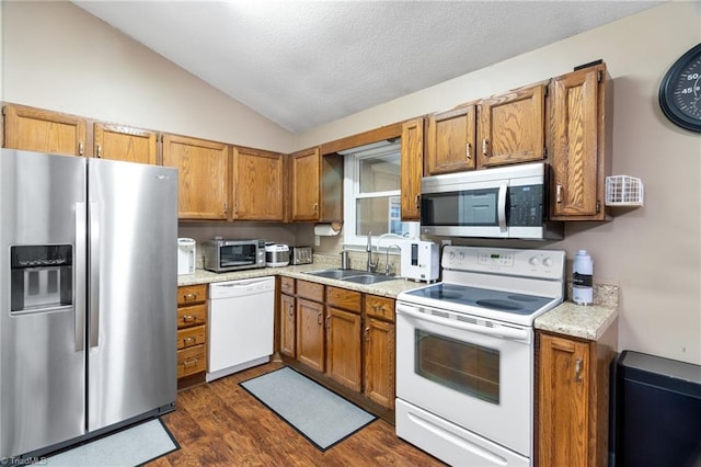 516 John St, Eden, NC 27288 - kitchen featuring stainless steel appliances, lofted ceiling, brown cabinetry, and a sink