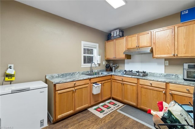 516 John St, Eden, NC 27288 - kitchen featuring under cabinet range hood, a sink, white fridge, dark wood finished floors, and stainless steel gas stovetop