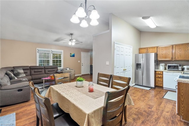 516 John St, Eden, NC 27288 - dining space with vaulted ceiling, ceiling fan with notable chandelier, wood finished floors, and baseboards