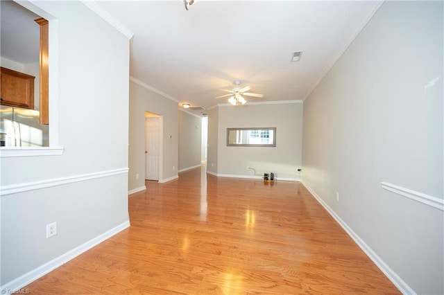 empty room with ceiling fan, ornamental molding, and light hardwood / wood-style flooring