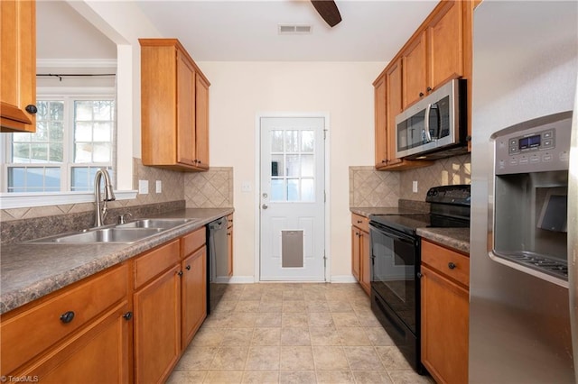 kitchen featuring sink, light tile patterned floors, decorative backsplash, and black appliances