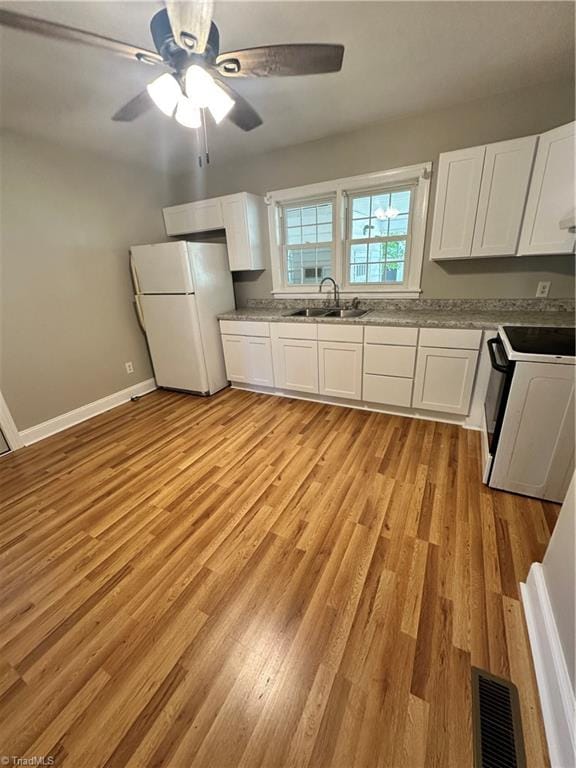 kitchen with light wood-type flooring, white cabinetry, white appliances, sink, and ceiling fan