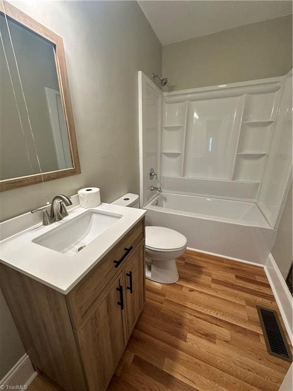 full bathroom featuring vanity, toilet, hardwood / wood-style flooring, and bathing tub / shower combination