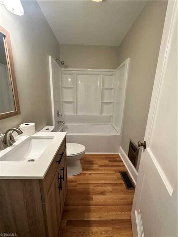 full bathroom featuring vanity, toilet, hardwood / wood-style floors, and  shower combination