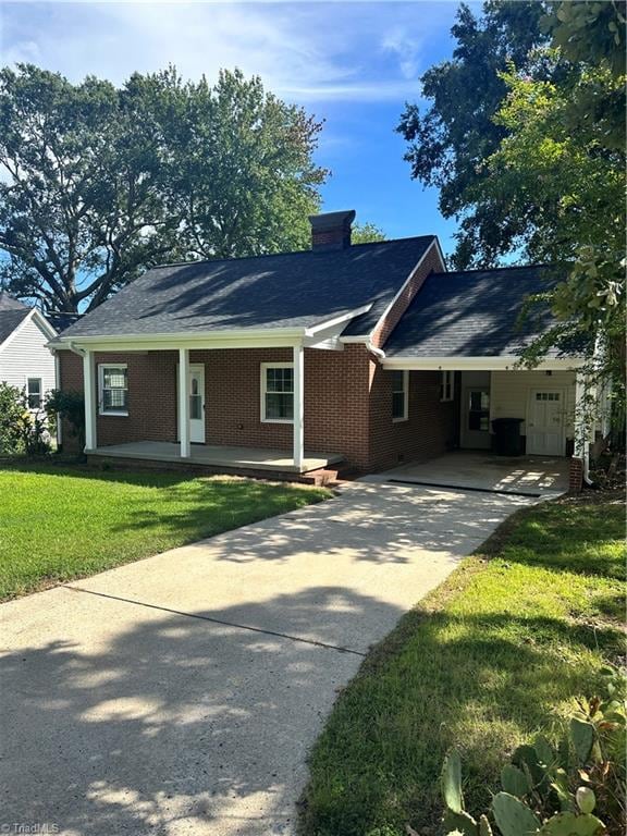 view of front of home with a front yard and a carport