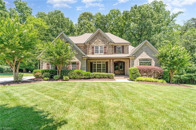 5216 Harley Stafford Dr, Oak Ridge, NC 27310 - view of front facade with a front yard, stone siding, and covered porch