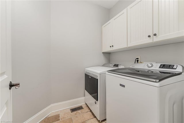 5216 Harley Stafford Dr, Oak Ridge, NC 27310 - laundry room featuring cabinet space, washing machine and clothes dryer, and light stone finish flooring