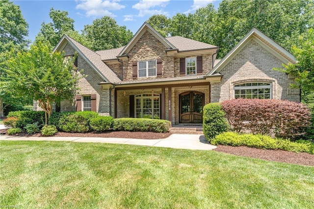 5216 Harley Stafford Dr, Oak Ridge, NC 27310 - view of front of home featuring a front lawn, brick siding, covered porch, and stone siding