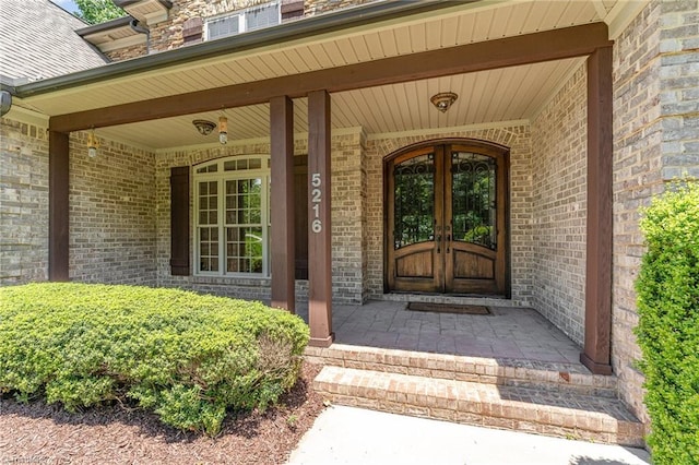 5216 Harley Stafford Dr, Oak Ridge, NC 27310 - doorway to property featuring a porch, brick siding, and french doors