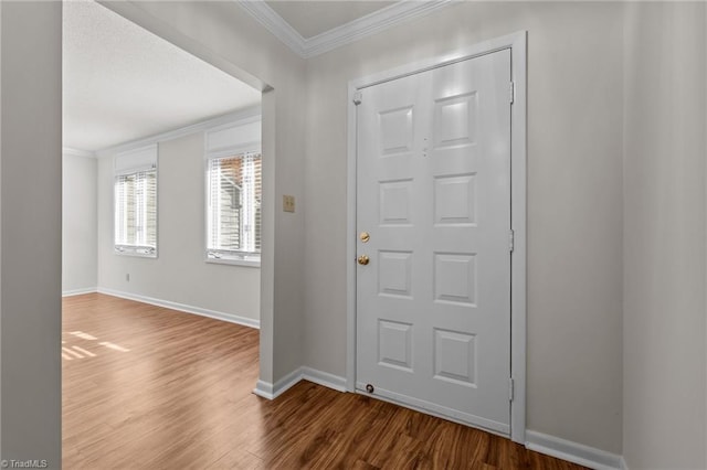 entryway with wood-type flooring and crown molding