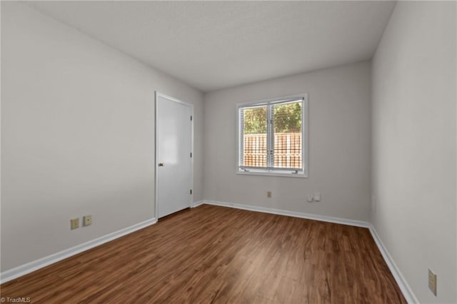 spare room with dark wood-type flooring