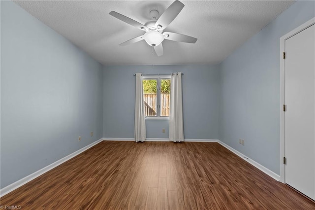 spare room with a textured ceiling, dark hardwood / wood-style flooring, and ceiling fan