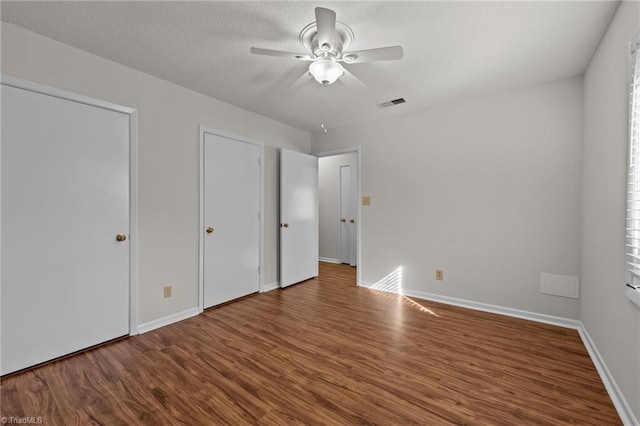 unfurnished bedroom with ceiling fan, wood-type flooring, and a textured ceiling