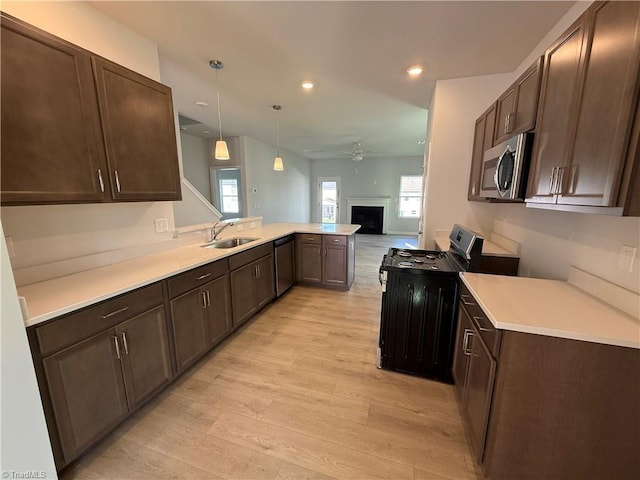 2533 Raspberry Hill Dr, Winston-Salem, NC 27106 - kitchen with a sink, stainless steel appliances, a peninsula, light wood-style flooring, and ceiling fan