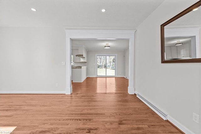 unfurnished living room with light hardwood / wood-style flooring, ornamental molding, and baseboard heating