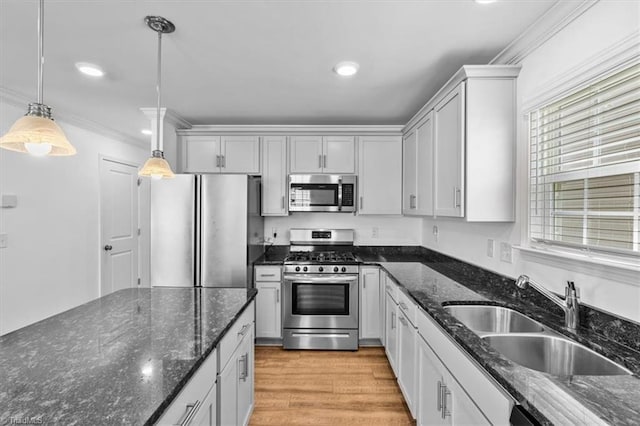 824 Sage Hill Dr, Jamestown, NC 27282 - kitchen featuring appliances with stainless steel finishes, ornamental molding, pendant lighting, light wood finished floors, and dark stone countertops