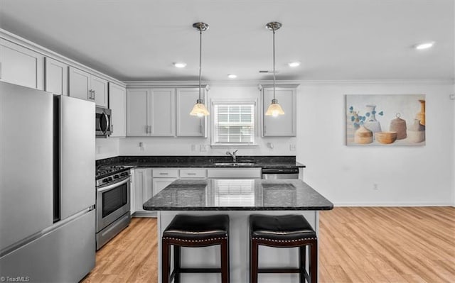 824 Sage Hill Dr, Jamestown, NC 27282 - kitchen with appliances with stainless steel finishes, a kitchen breakfast bar, dark stone counters, light wood-type flooring, and ornamental molding