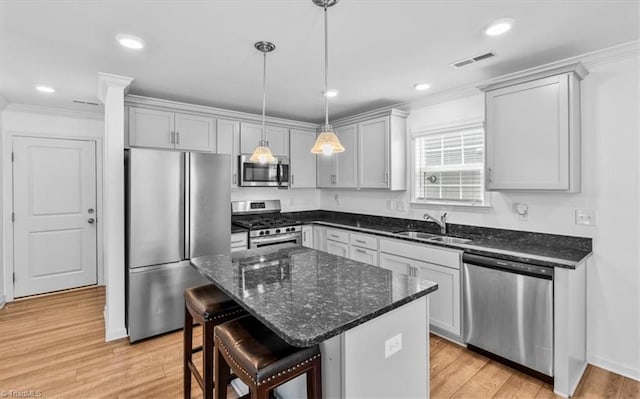 824 Sage Hill Dr, Jamestown, NC 27282 - kitchen featuring stainless steel appliances, light wood-style floors, a breakfast bar, crown molding, and pendant lighting
