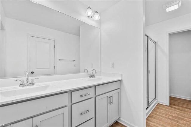 824 Sage Hill Dr, Jamestown, NC 27282 - full bathroom with double vanity, a shower stall, and wood finished floors