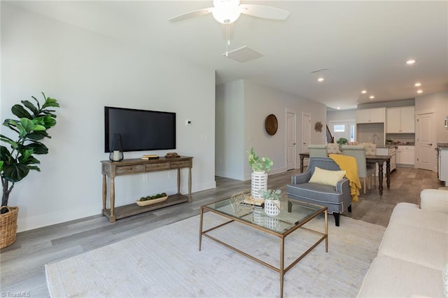 living area featuring light wood finished floors, recessed lighting, ceiling fan, and baseboards