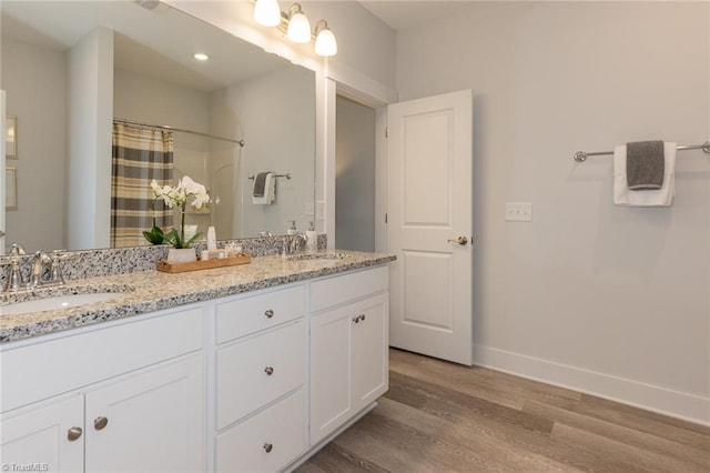 full bathroom with wood finished floors, double vanity, baseboards, and a shower with curtain