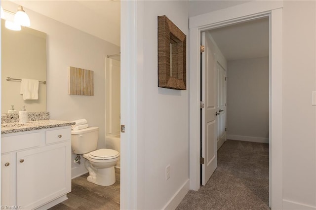 bathroom with vanity, toilet, shower / washtub combination, and baseboards