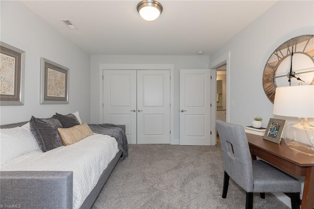 carpeted bedroom featuring a closet and an office area