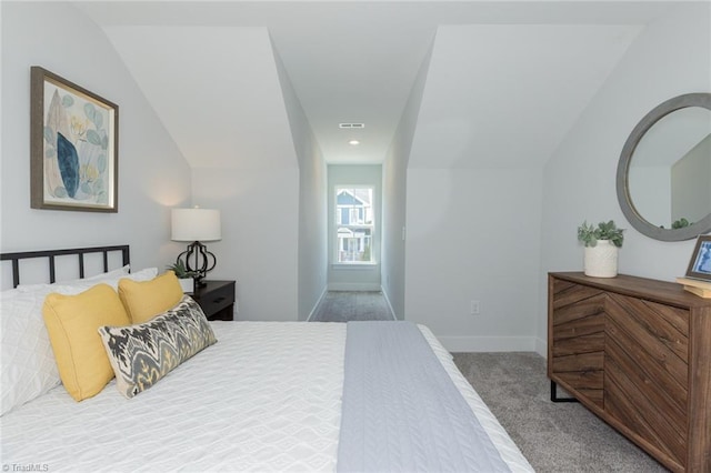 carpeted bedroom with vaulted ceiling and baseboards