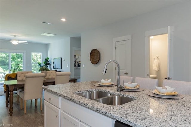kitchen featuring a sink, white cabinets, ceiling fan, light stone counters, and recessed lighting